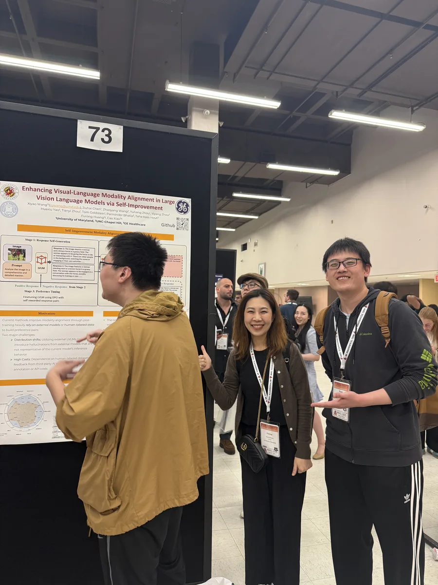 Furong Lab researchers discussing a poster at a conference