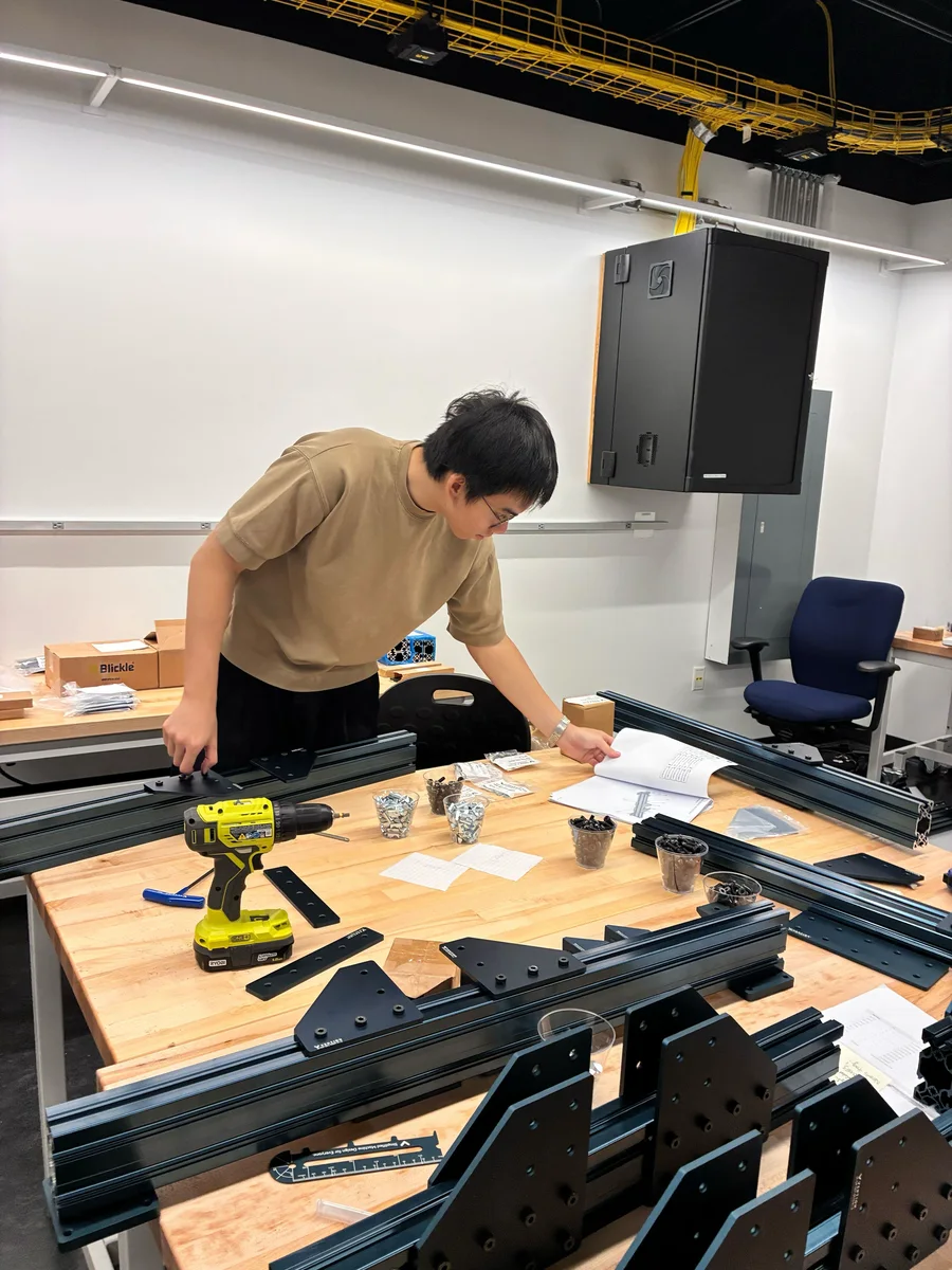 A researcher assembling robotics equipment at a workbench